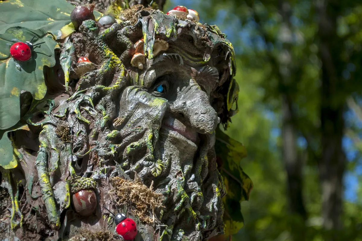 Moosbewachsene Trollfigur im Grünen